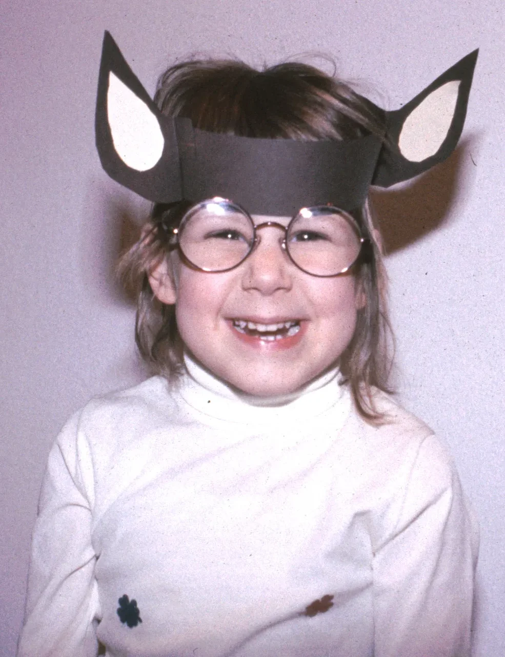 Lachendes Mädchen mit Papiereselsohren